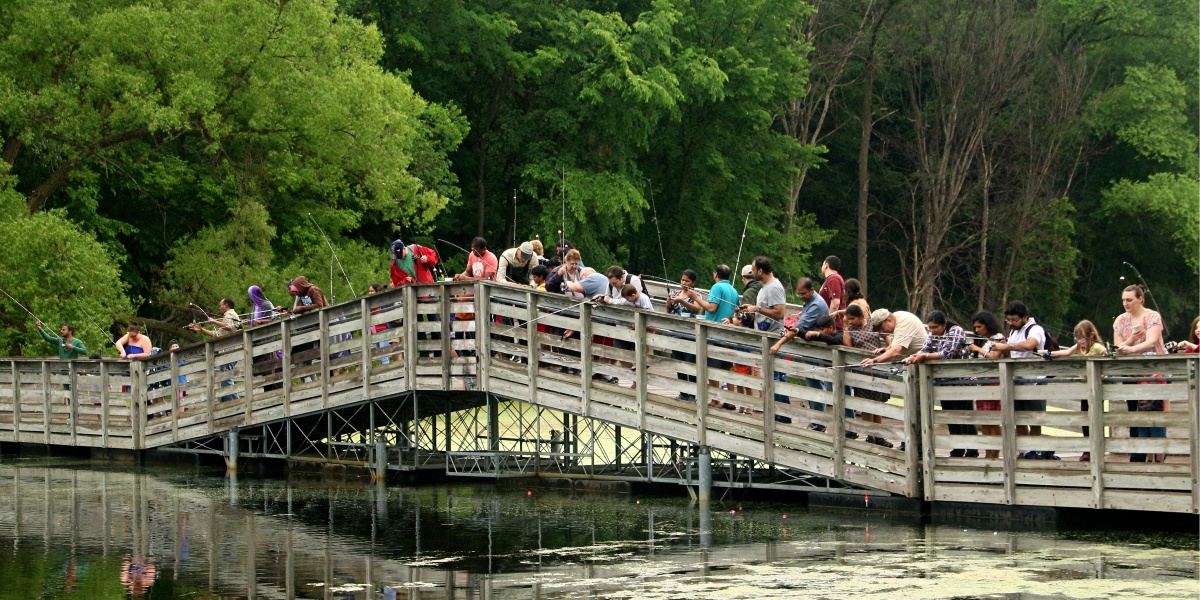 LakeFest attendees fish from a bridge