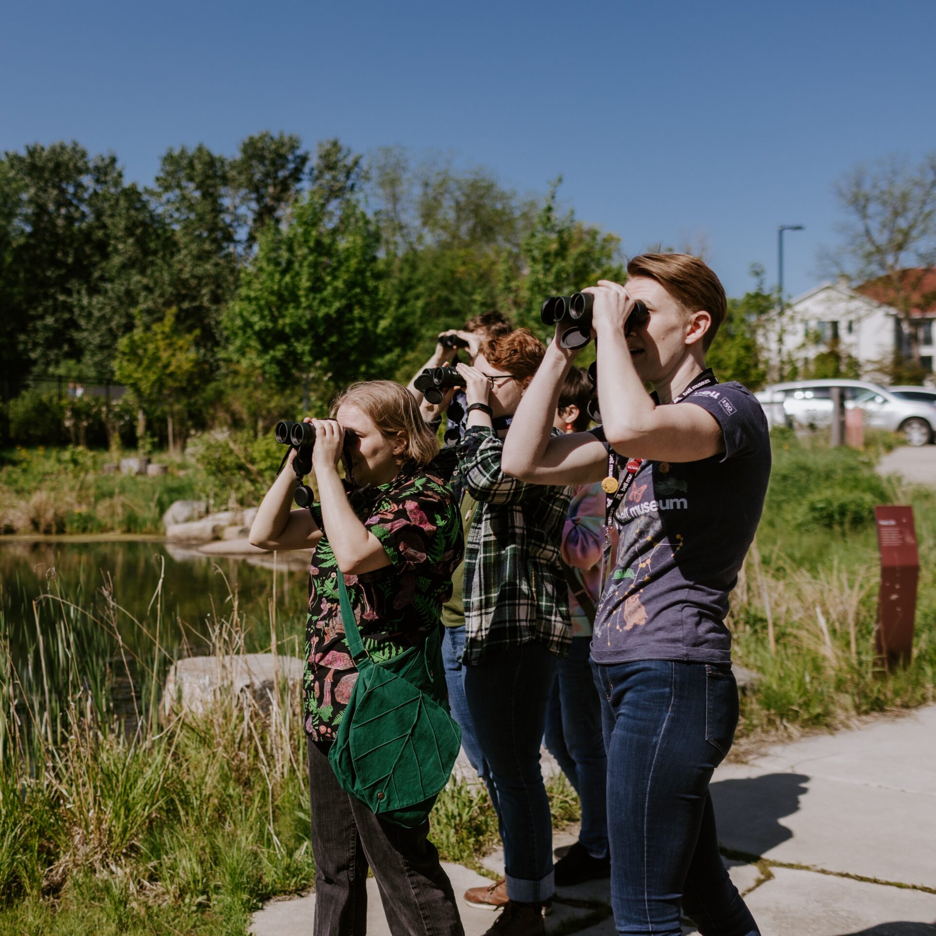 Kelsey with visitors looking through binoculars.