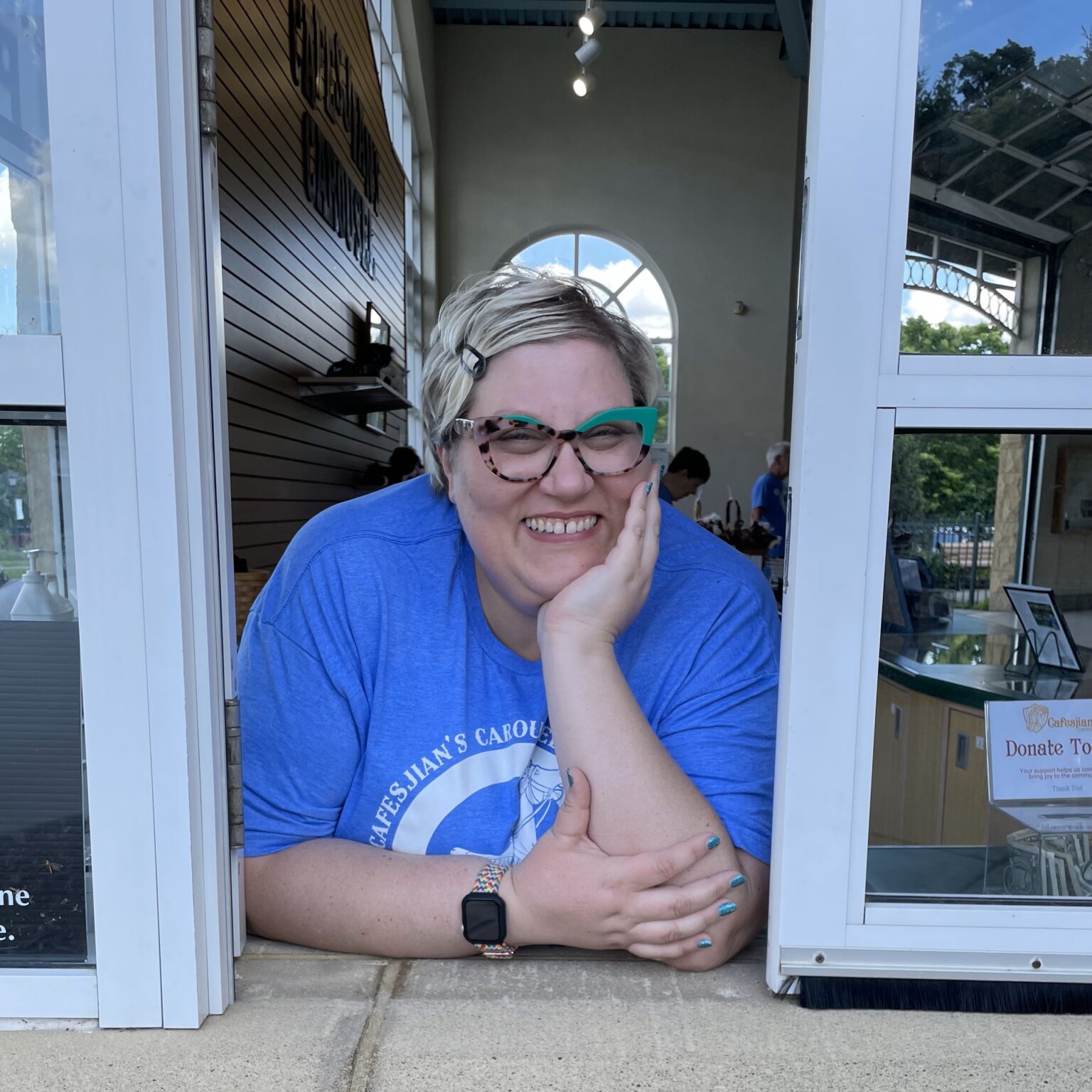Volunteer stands ready to help families buy tickets to top family destination in St. Paul, a family friendly carousel near Como Zoo